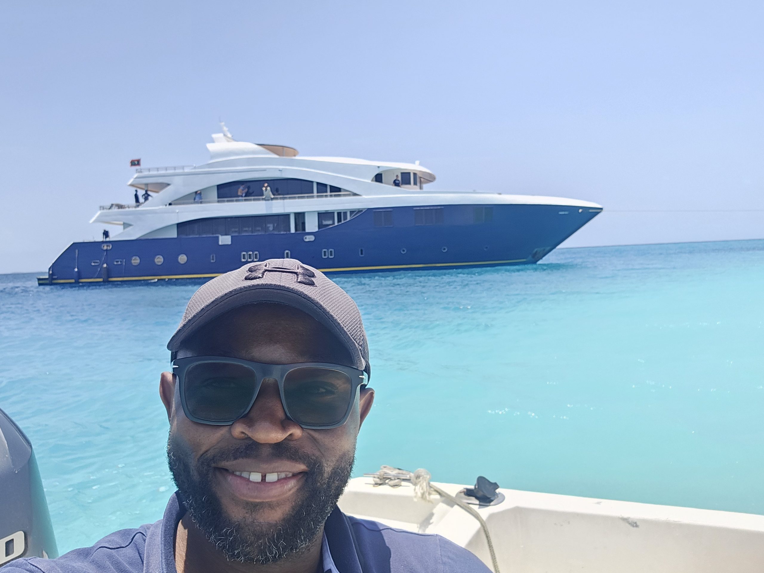 A man smiling in front of a boat