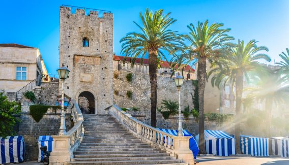 Korcula Old Town Entrance with blue sky and palm trees